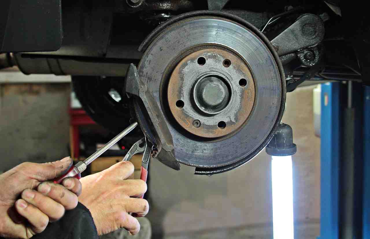 Automotive repair professional performing custom fabrication and restoration work on a vehicle body panel, representing Automotive business startup funding, garage building loans, auto repair shop expansion loans, and automotive CRM financing used to support facility growth, equipment investments, customer management technology, and long-term business development.