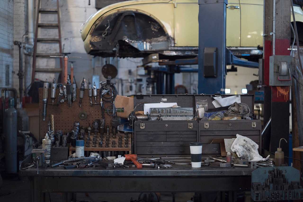 Automotive repair facility with vehicle lift, technician toolboxes, and service equipment in a working garage environment, representing Transmission equipment financing, auto shop real estate financing, EV service center financing, frame machine financing, and tire business funding for automotive businesses expanding operations and upgrading equipment.