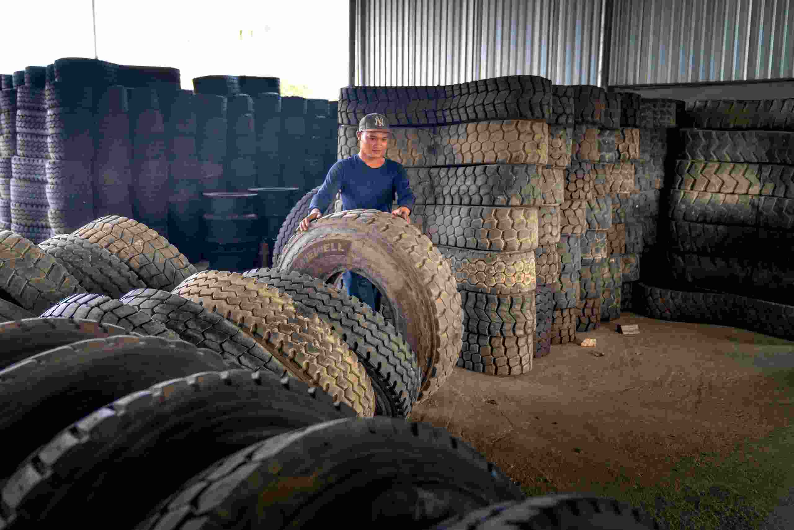 Technician organizing large commercial truck tires inside a tire warehouse, representing Body shop financing, performance shop financing, collision center expansion financing, auto service center growth funding, and tire shop financing for equipment purchases, inventory expansion, and automotive business growth.