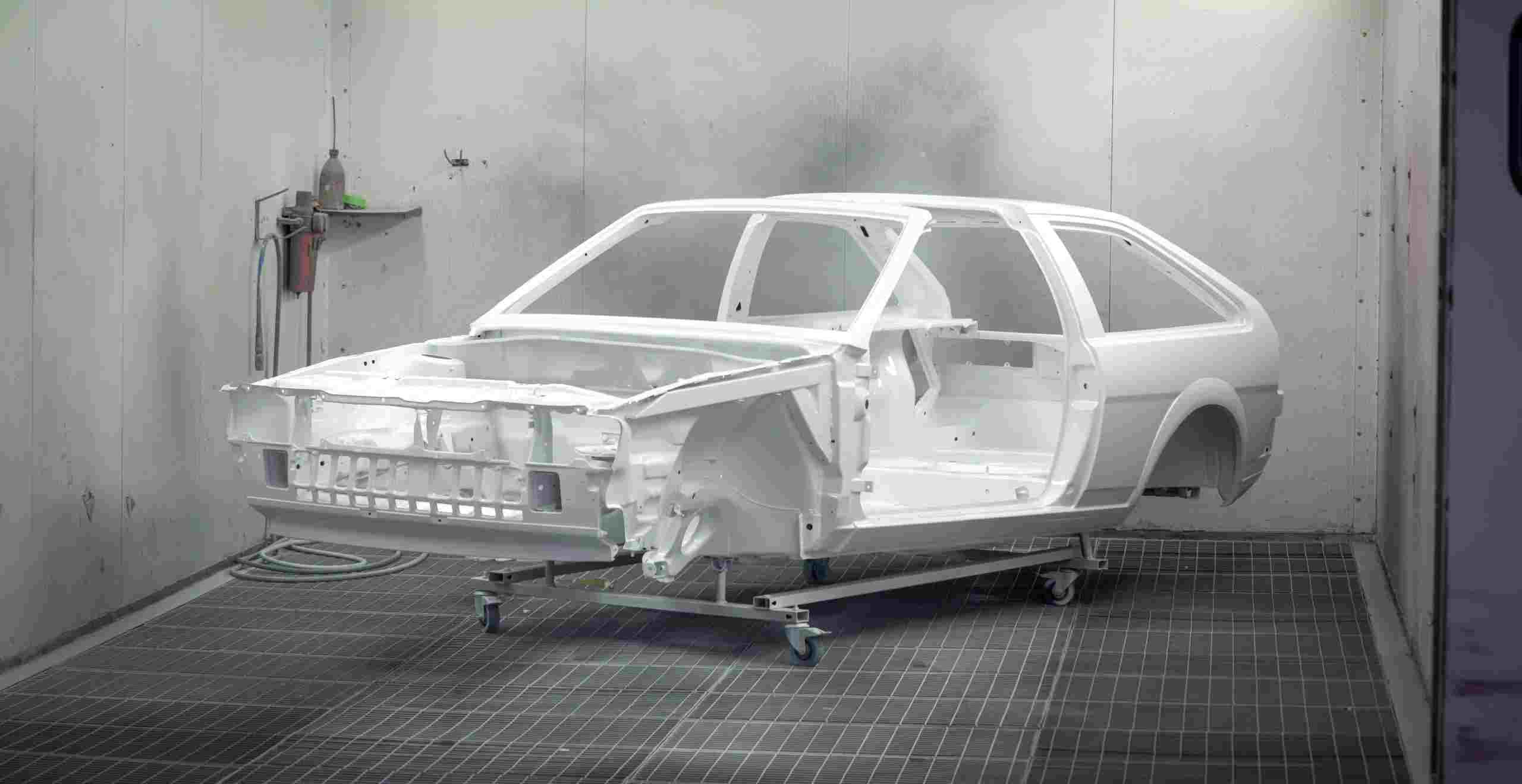 Classic vehicle body shell inside a professional paint booth undergoing restoration and refinishing, representing Garage financing specialists, EV charging equipment financing, repair shop technology upgrades, apply for auto shop loan, and tire shop financing for modern automotive service businesses investing in equipment, technology, and facility growth.