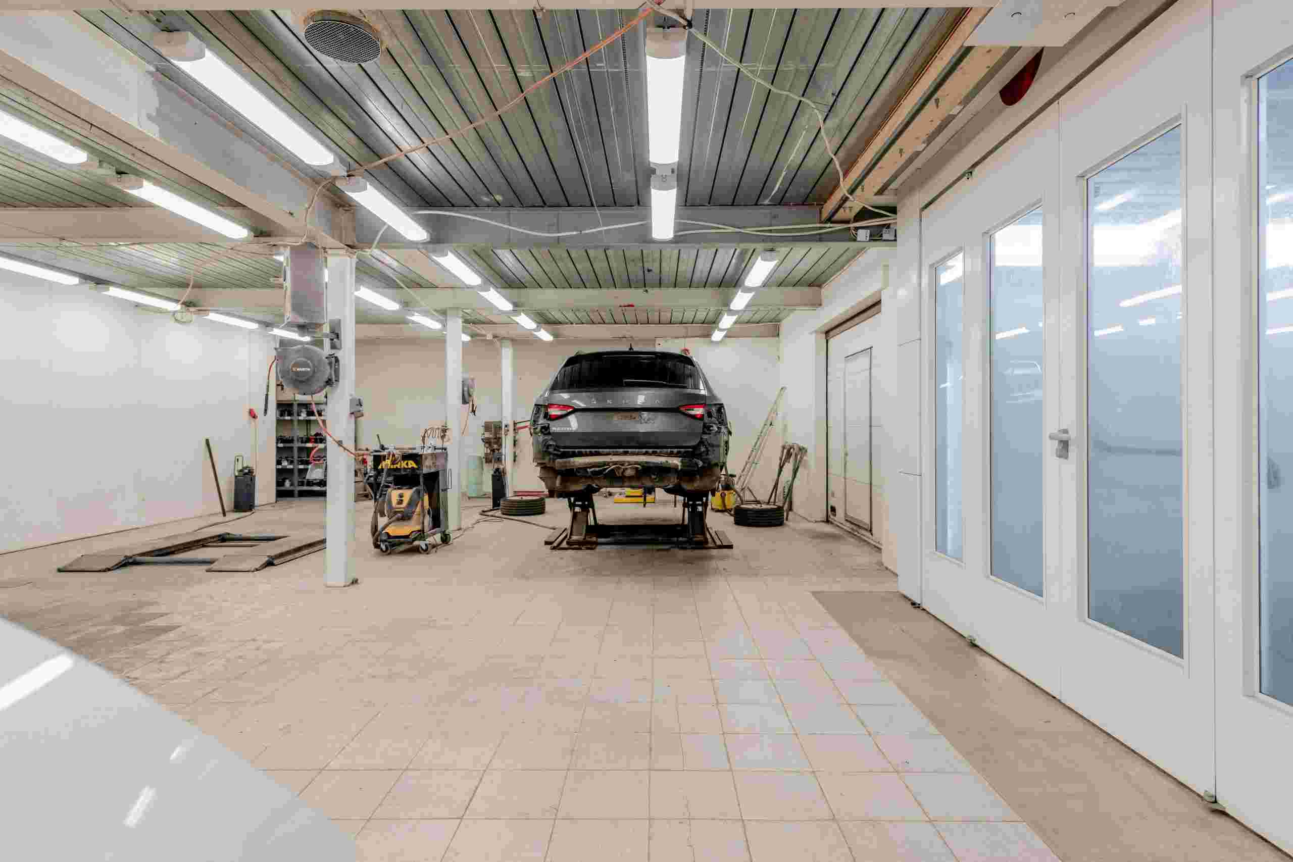Modern automotive service facility with vehicle positioned in a clean repair bay, representing vehicle repair shop financing, tire changer financing, automotive funding solutions, automotive financing companies, and auto repair capital providers helping repair businesses acquire equipment, facilities, and growth capital.