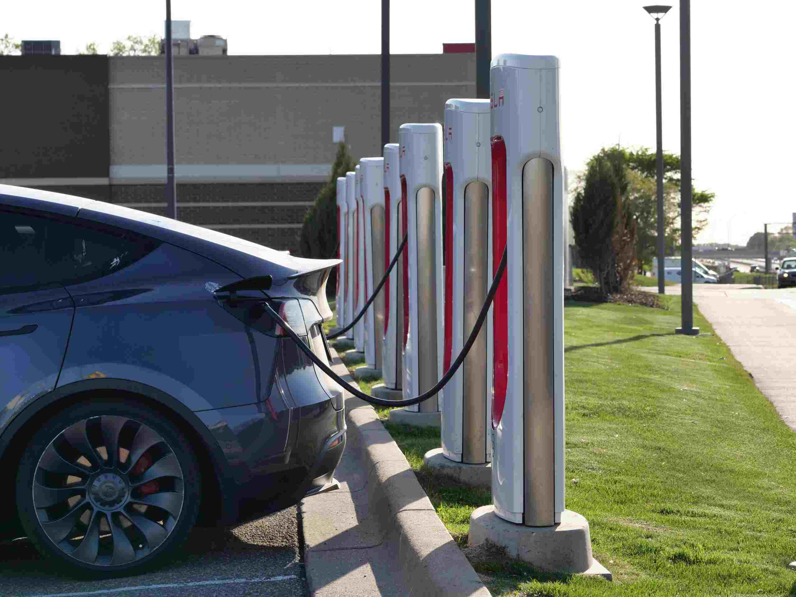 Electric vehicle charging station with multiple chargers powering a modern EV, representing Automotive tool financing, EV repair shop financing, automotive analyzer financing, brake lathe financing, and collision repair equipment financing for automotive service businesses investing in advanced technology and repair capabilities.