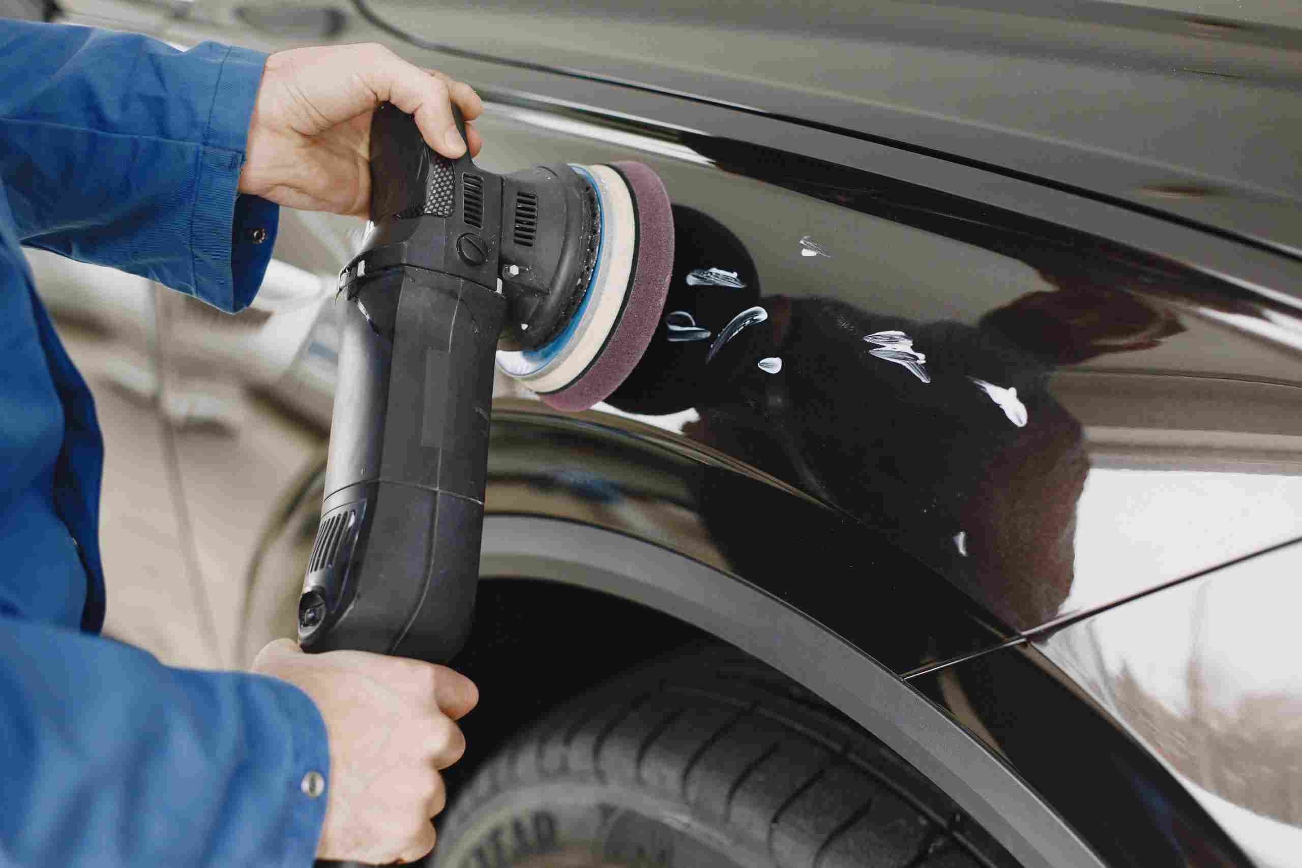Automotive technician using a power buffer to restore a vehicle’s paint finish in a professional repair facility, representing garage acquisition financing, vehicle diagnostic system financing, automotive operating funds, alignment rack financing, and hydraulic lift financing for growing automotive service businesses.