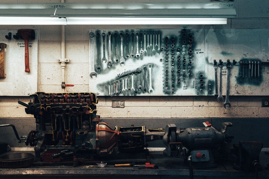 Automotive mechanic workbench with engine components and organized hand tools, representing Startup funding for mechanics, auto service center growth funding, hydraulic lift financing, dent repair equipment financing, and tire business funding for automotive business owners.