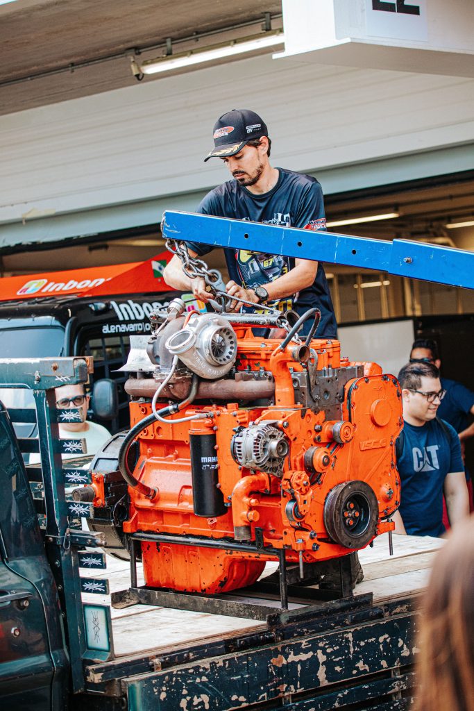 Mechanic working with a large truck engine and turbocharger representing truck repair shop financing, automotive funding solutions, automotive property financing, repair order software financing, and fleet vehicle repair financing for automotive and commercial vehicle repair businesses.