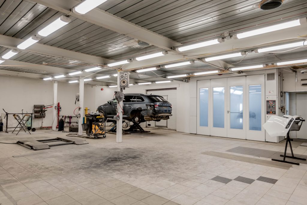 Modern automotive repair shop with a vehicle raised on a service lift and professional repair equipment, representing Automotive management system financing, electric vehicle maintenance funding, commercial fleet service funding, and auto repair shop expansion loans for automotive service businesses.