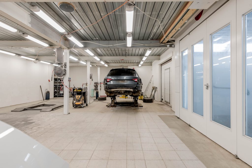 Automotive repair shop with a vehicle raised on a service lift, representing Tire service center financing, mechanic shop startup financing, alignment rack financing, automotive testing equipment loans, and garage line of credit options for automotive businesses.
