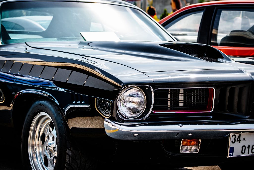 Classic black performance car with polished wheels and a hood scoop, representing Shop management software financing, automotive scheduling software, how to finance an auto repair shop, and financing multiple auto repair locations for automotive service businesses.