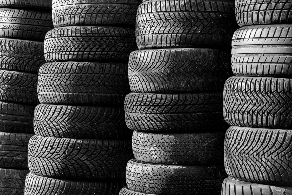 Stacks of automotive tires representing EV charging equipment financing, garage building loans, wheel alignment equipment financing, fleet repair facility funding, and EV repair shop financing for automotive service businesses.